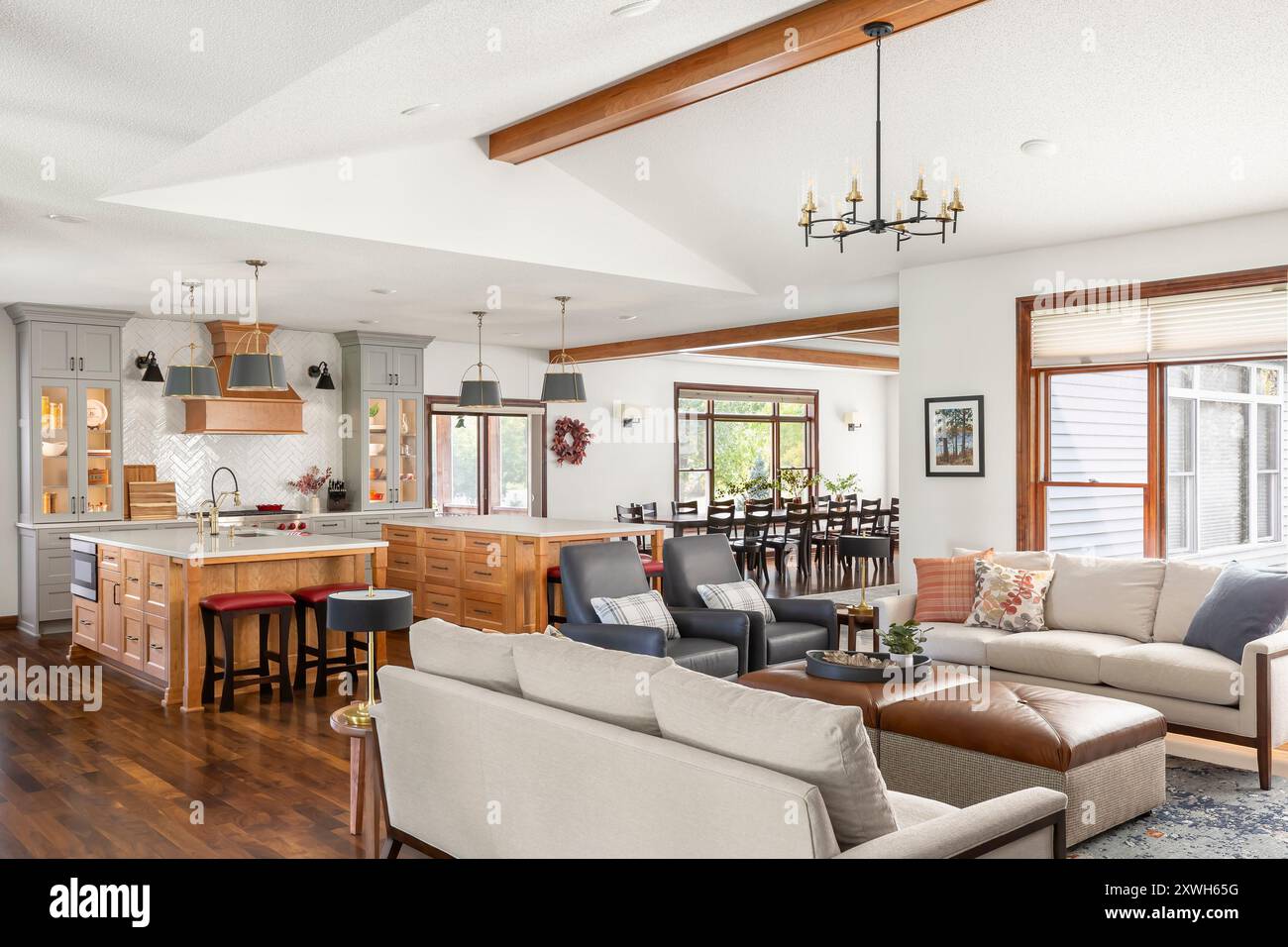 Living room seating area next to large kitchen with two islands and