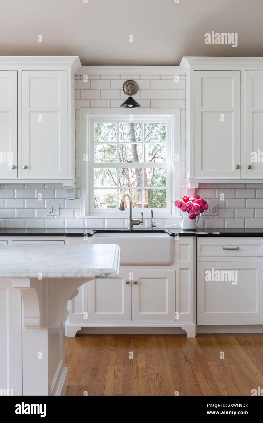 Farmhouse sink in all white kitchen with black details Stock Photo - Alamy
