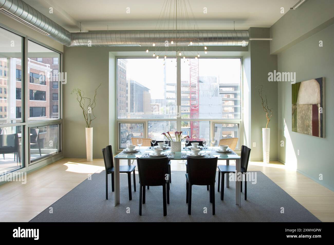 Modern dining room with view to building construction outside window ...