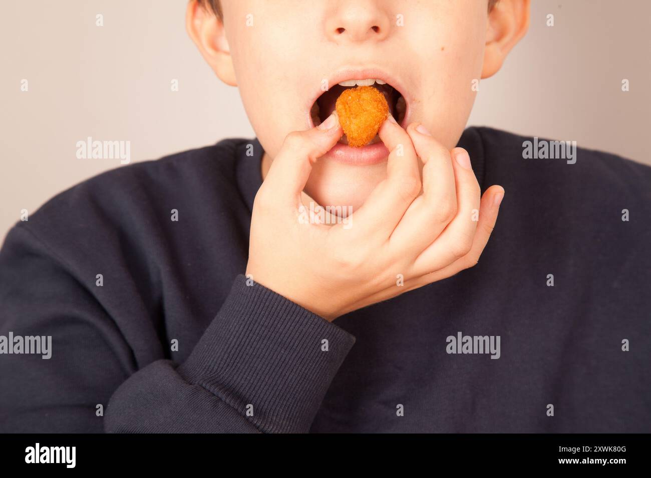 Caucasian man eating golden fried chicken balls, American fast food culture, cooked chicken pieces Stock Photo