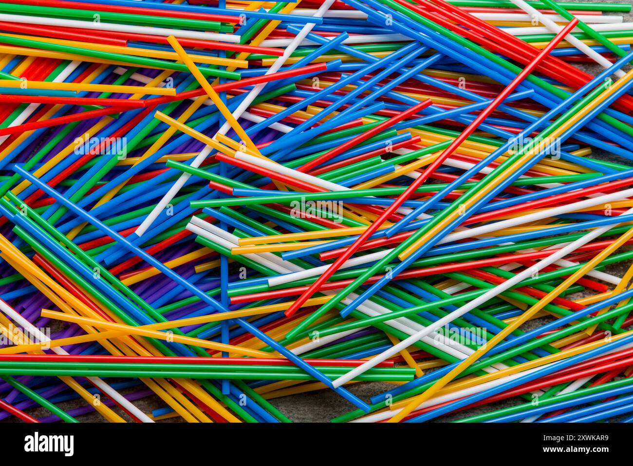 many multi-colored plastic tubes for cocktail on Colored background, top view. Stock Photo