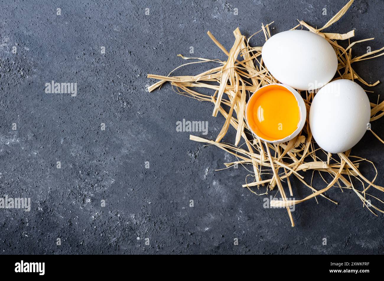 Raw white farm chicken eggs with egg yolk on rustic table Stock Photo