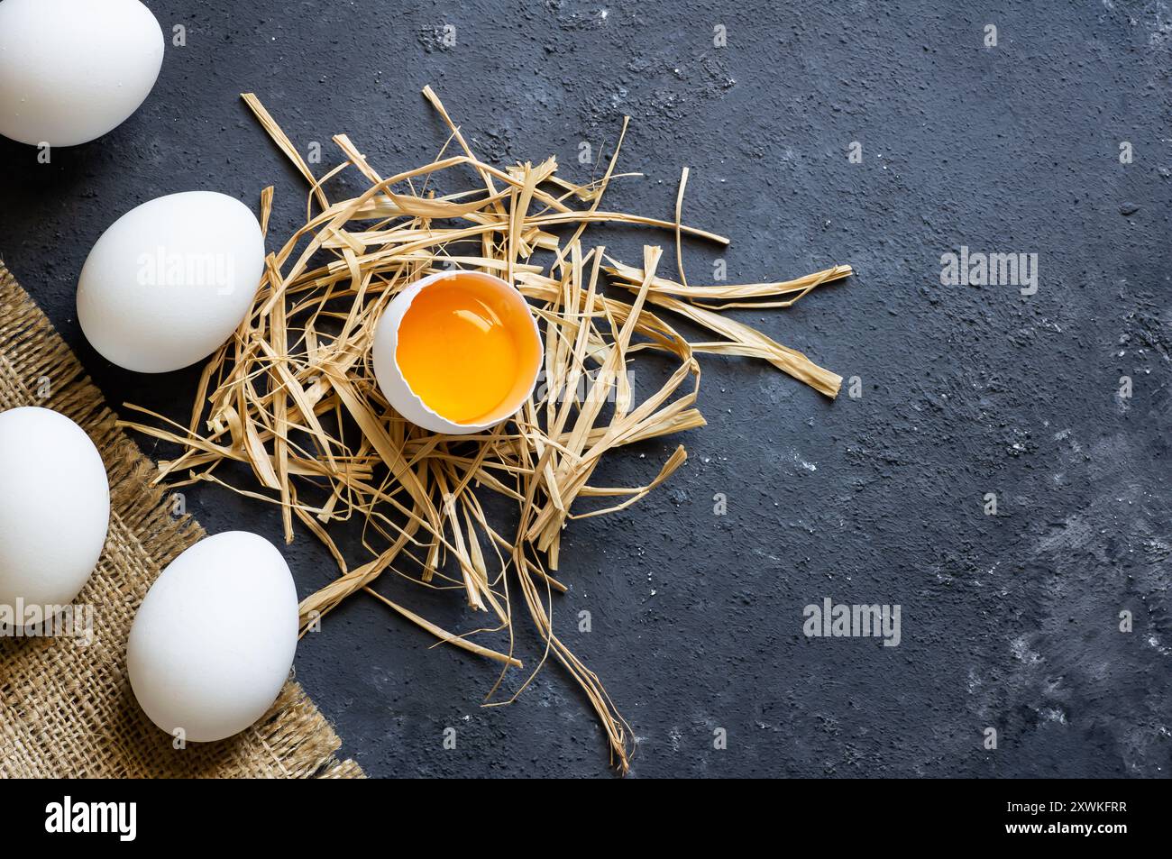 Raw white farm chicken eggs with egg yolk on rustic table Stock Photo