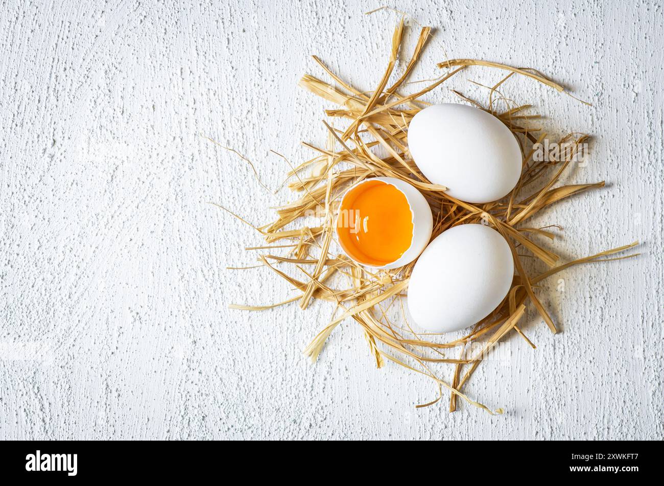 Raw white farm chicken eggs with egg yolk on rustic table Stock Photo