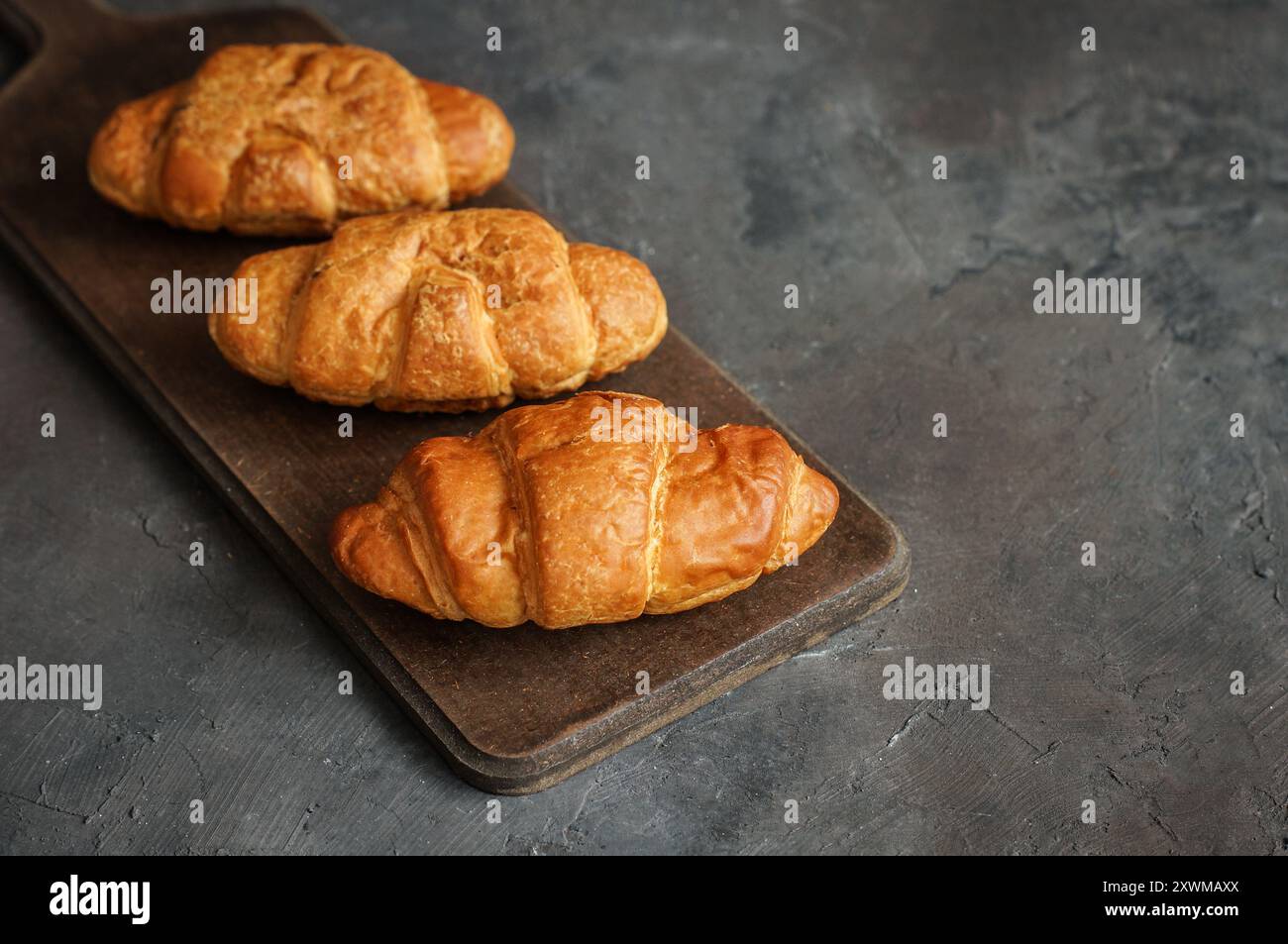Close up Fresh baked croissants on cutting board Stock Photo