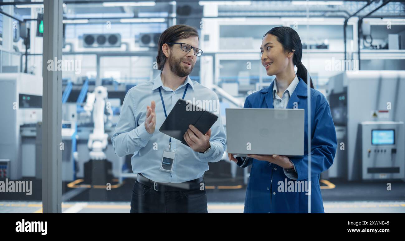Caucasian Engineer and Asian Female Project Manager Standing in Office ...