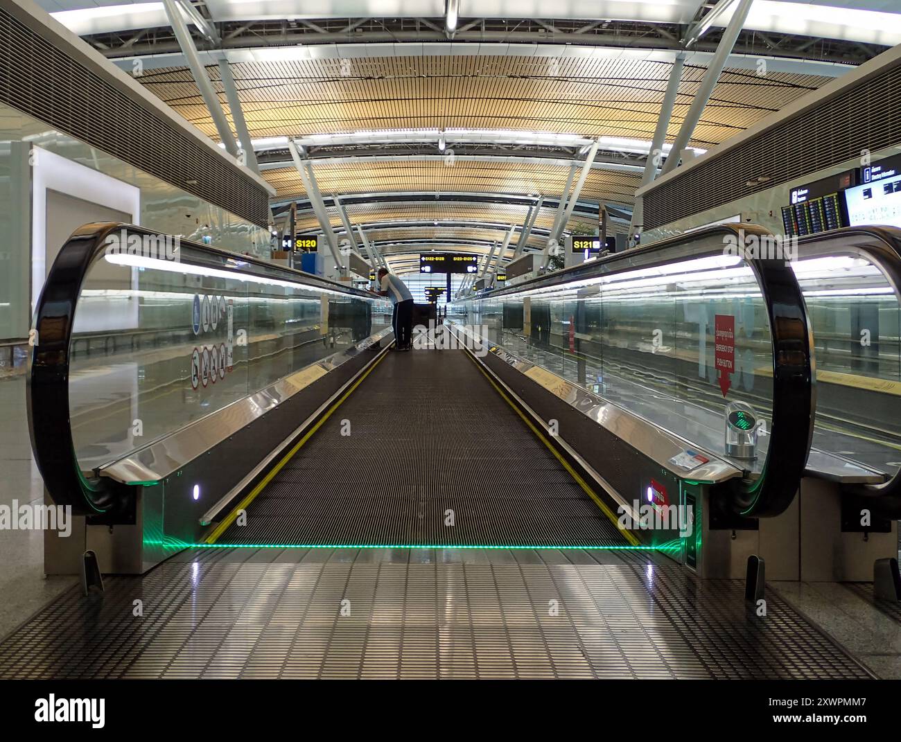 A staff with a wheelchair uses the walkway in Satellite Terminal 1 (SAT ...