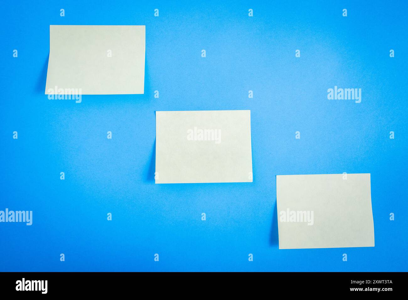 Three empty sticky notes, on a blue background Stock Photo - Alamy