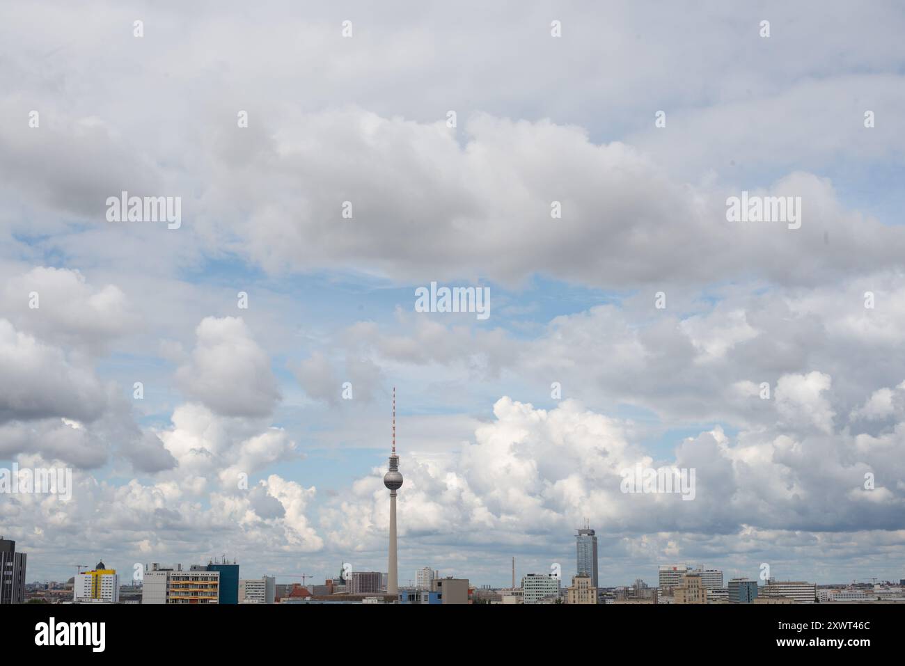 A scenic view of Berlin's cityscape featuring the iconic TV tower under a partly cloudy sky. This image captures the vastness of the sky and urban architectural elements, providing a metaphor for open possibilities. Stock Photo