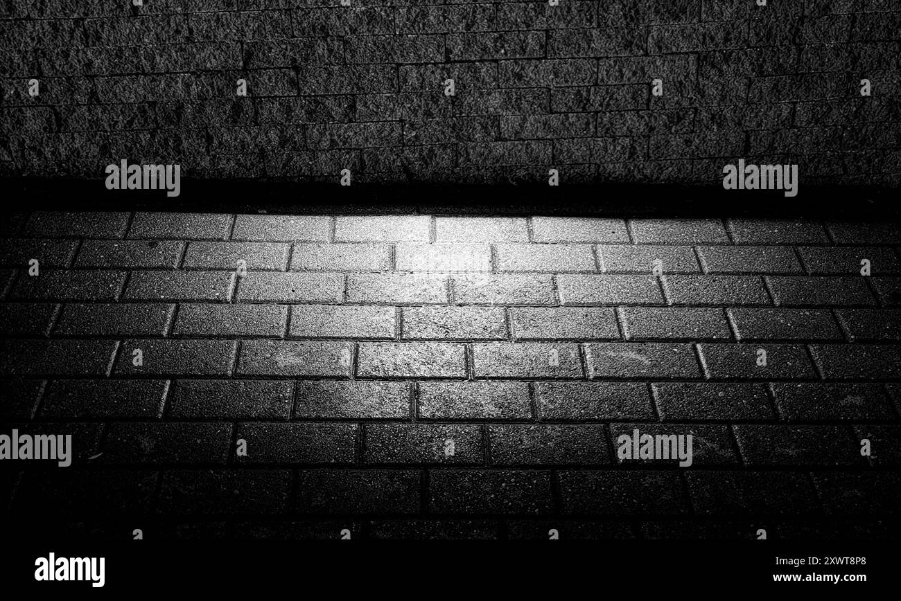 Pavement Floor Illuminated by Street Light: Pattern and Texture – Light and Shadow. Black and white. Glow in the dark. Stock Photo