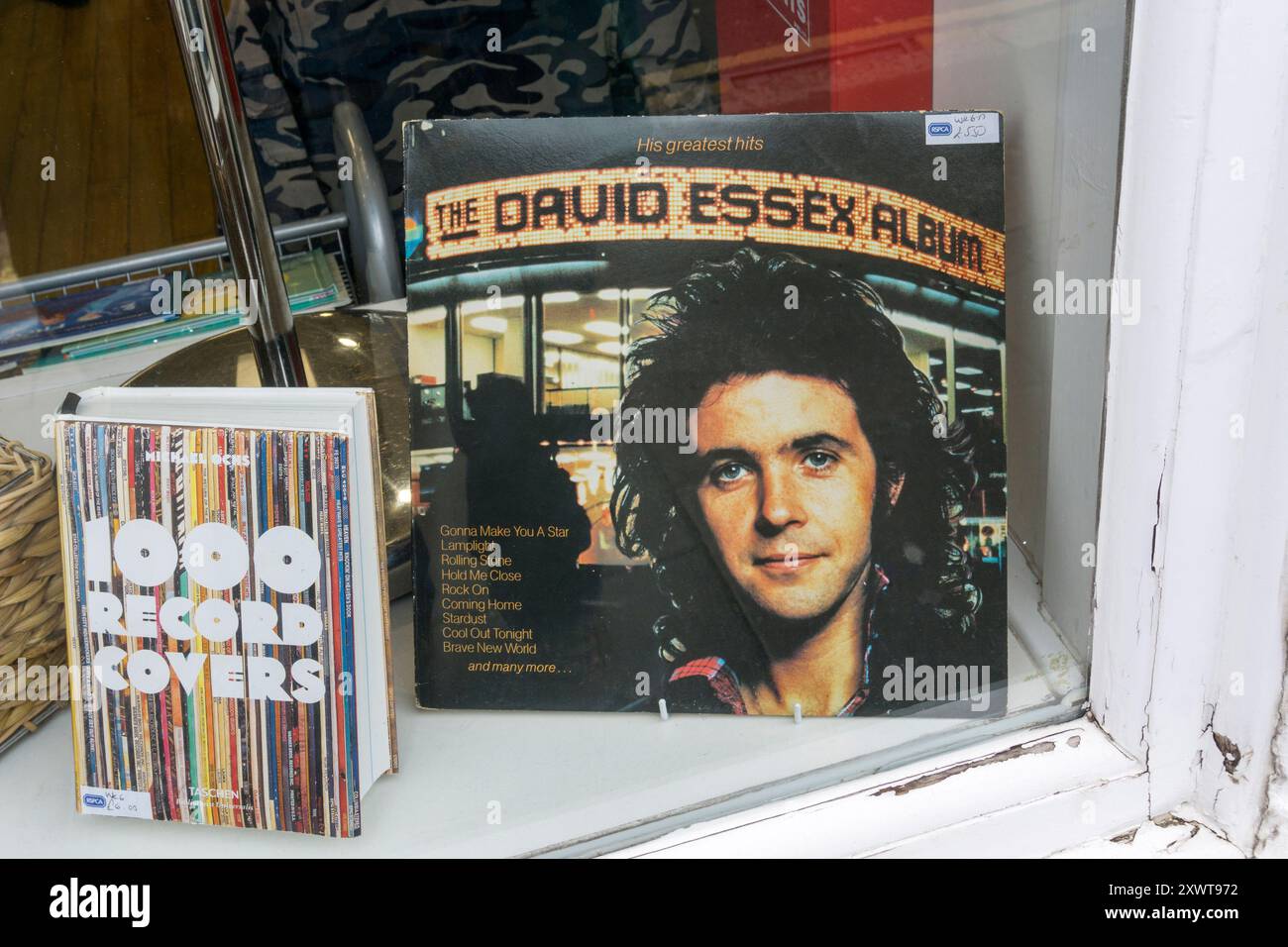 The David Essex Album vinyl LP and 1000 Record Covers by Michael Ochs for sale secondhand in a charity shop window. Stock Photo