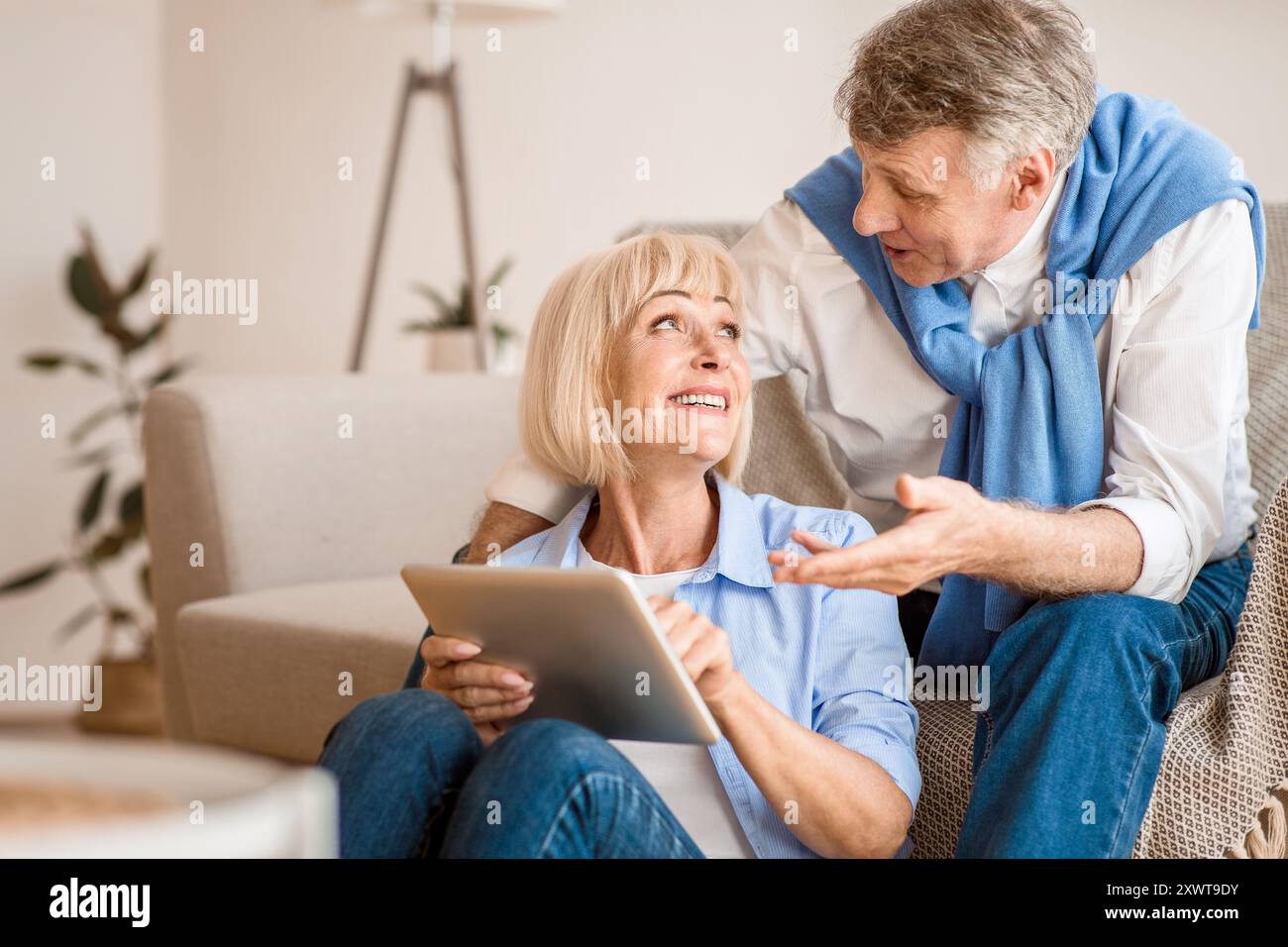 Modern senior spouses using digital tablet together Stock Photo