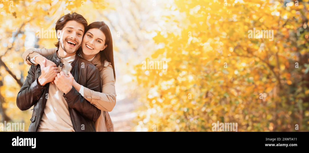 Positive woman hugging her man from behind, posing at park Stock Photo ...
