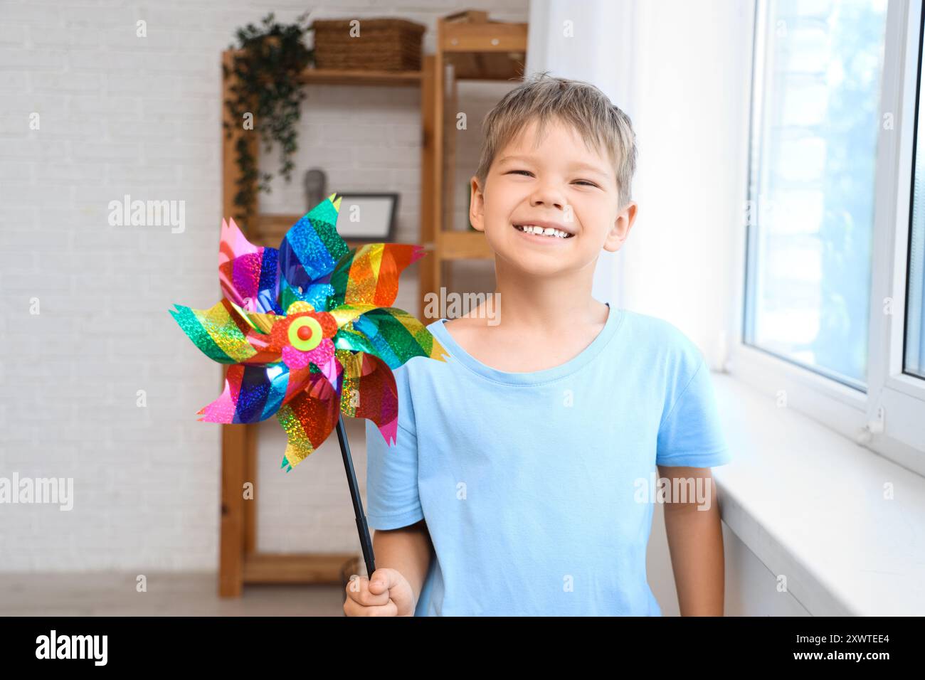 Windmill Boy Cute little boy with toy windmill at home Stock Photo - Alamy
