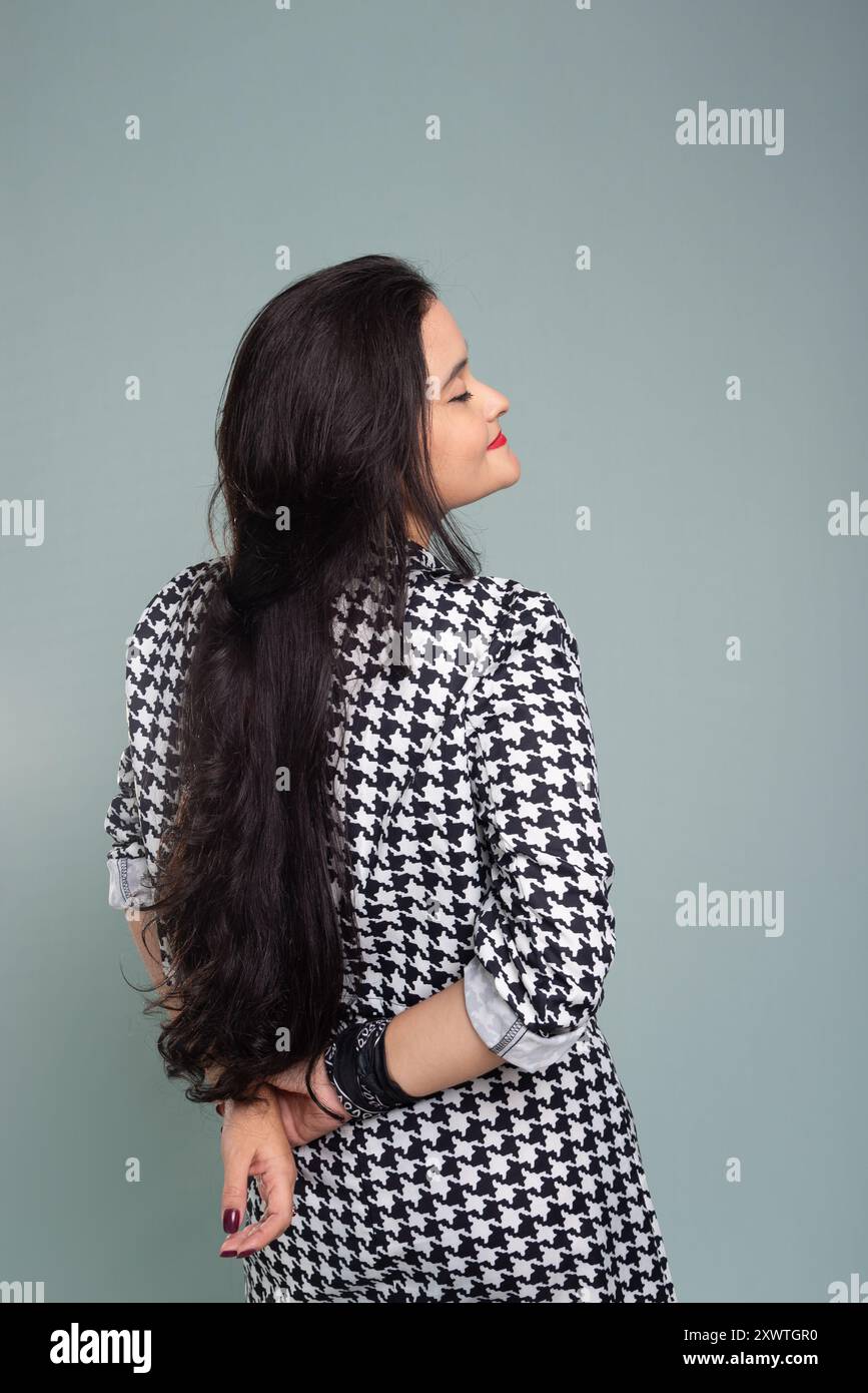 Beautiful woman standing with her back to the camera calmly posing for ...