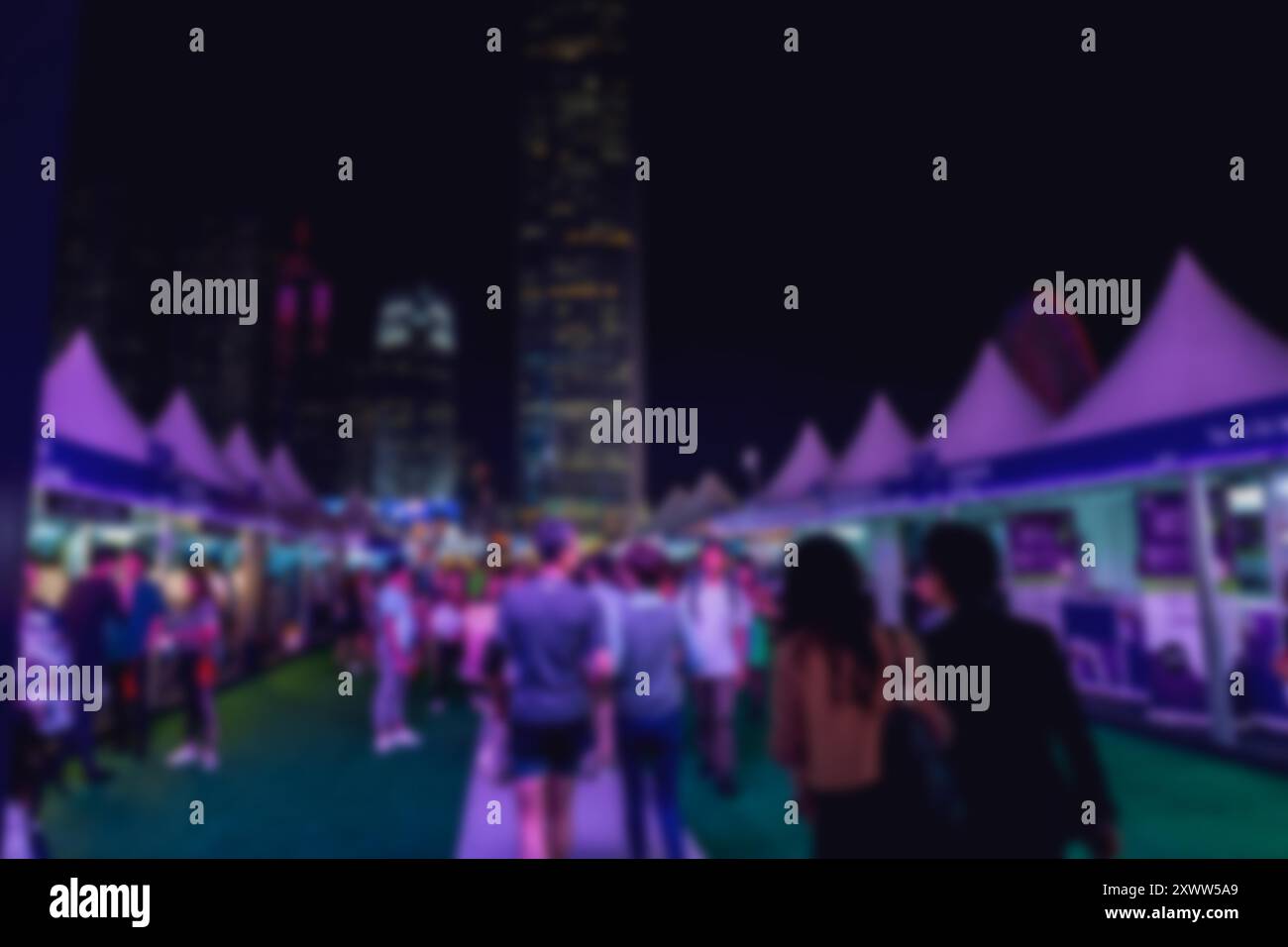 Blurry night scene in Hong Kong with a crowd of people walking by ...
