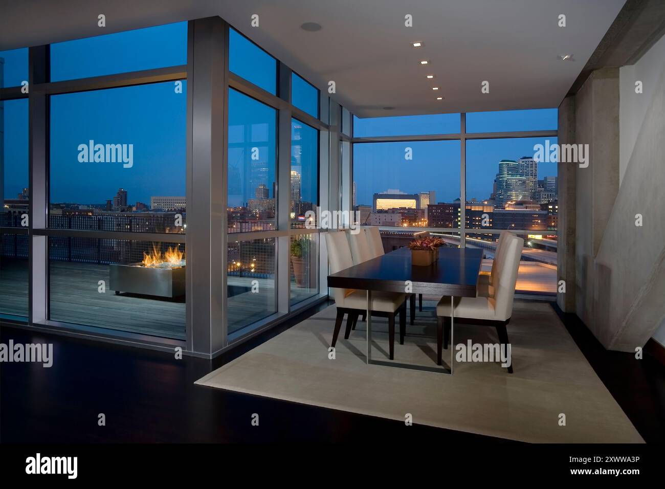 Modern dining area with floor to ceiling windows with view of city at ...