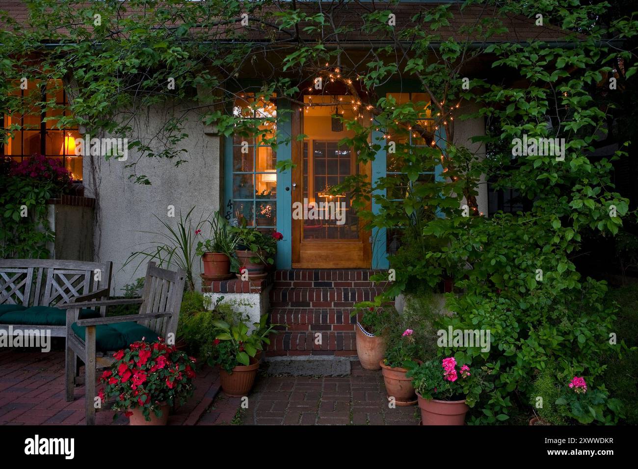 Appealing house entrance with string lights and interior lights on at ...