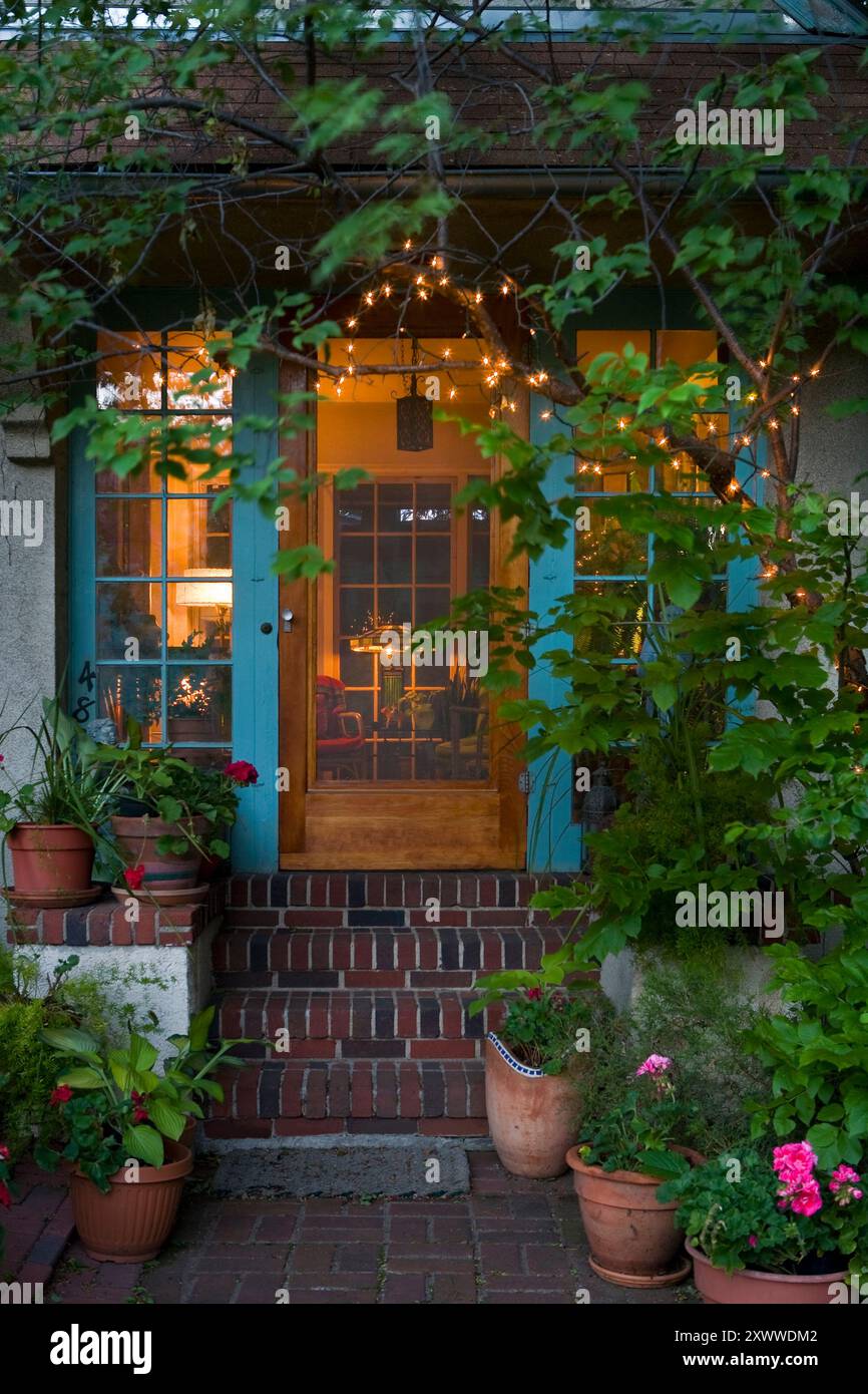 Appealing house entrance with string lights and interior lights on at ...