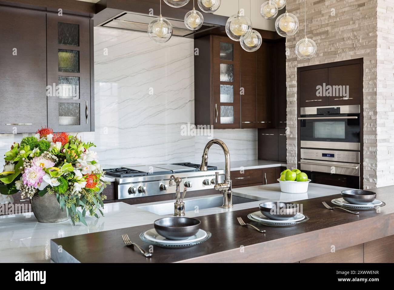 Dark wood cabinets and counter in modern kitchen with large marble ...
