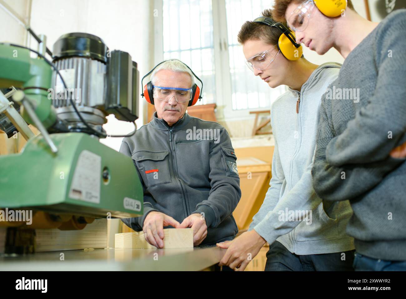 engineer and apprentices using automated milling machine Stock Photo