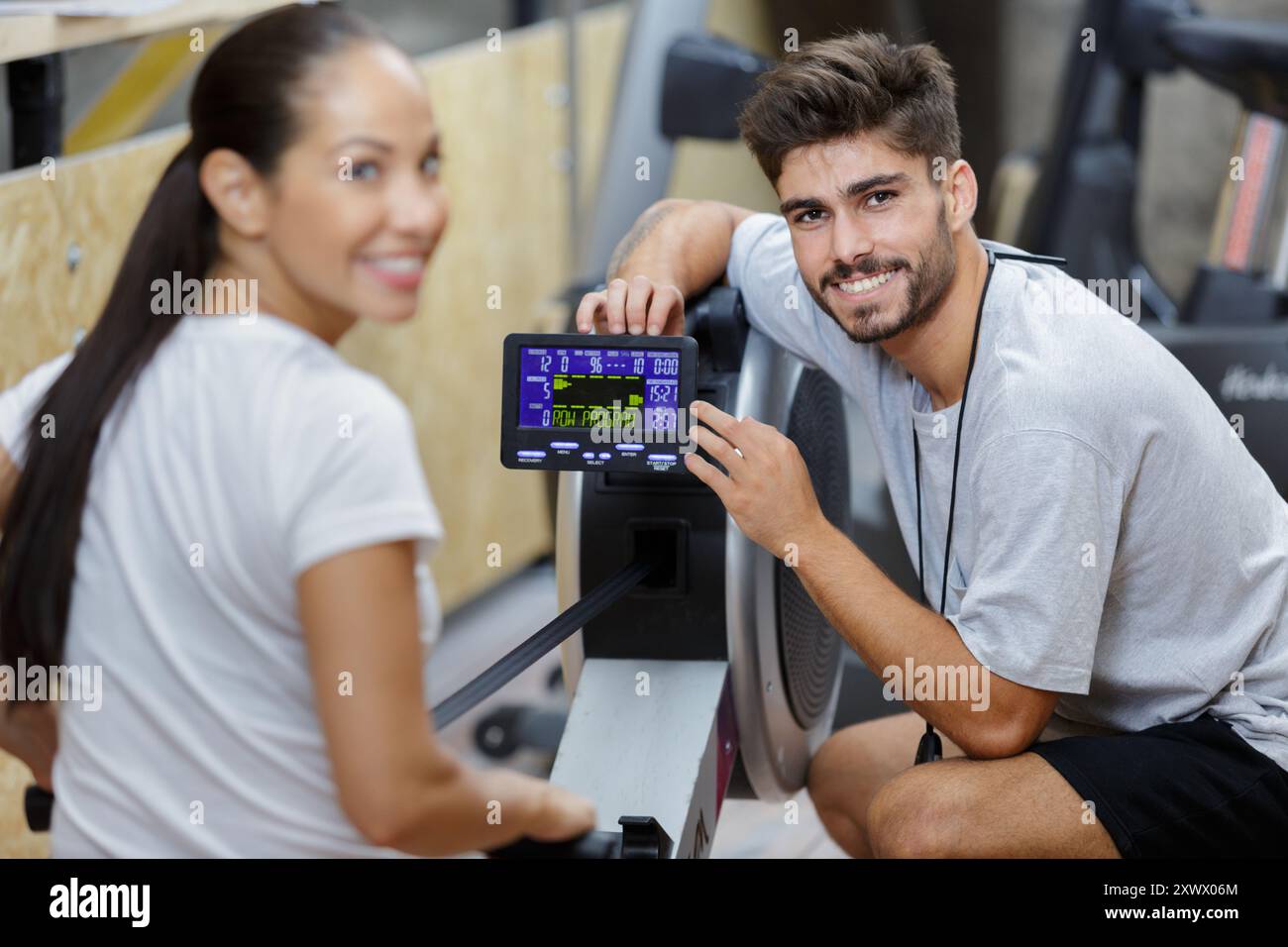 a couple and rowing machine workout Stock Photo - Alamy