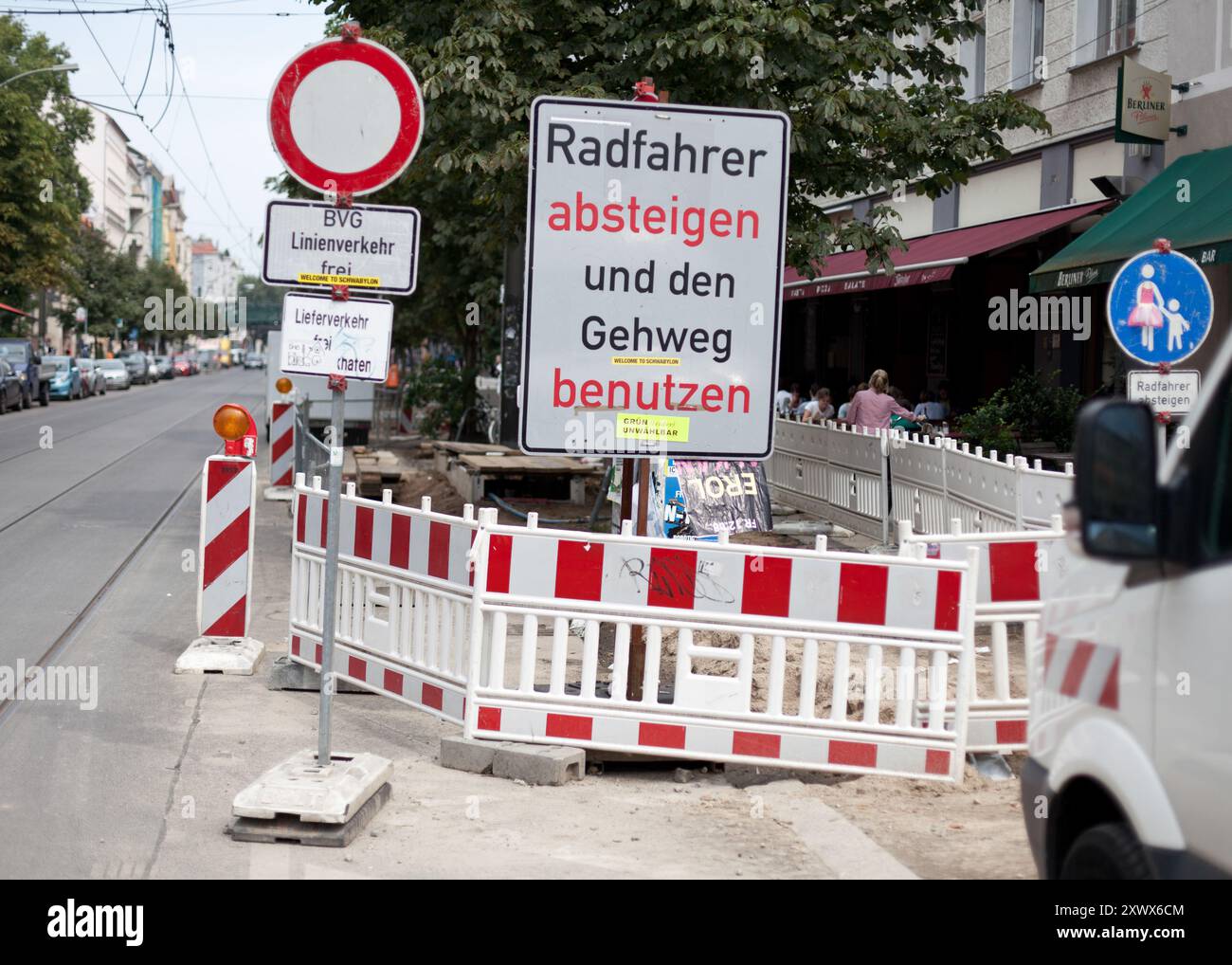 A collection of traffic signs and barriers on Kastanienallee in Prenzlauer Berg, Berlin, highlighting bicycle and pedestrian navigation during urban road maintenance in 2011. Vibrant street life and infrastructure in a busy city setting. Stock Photo