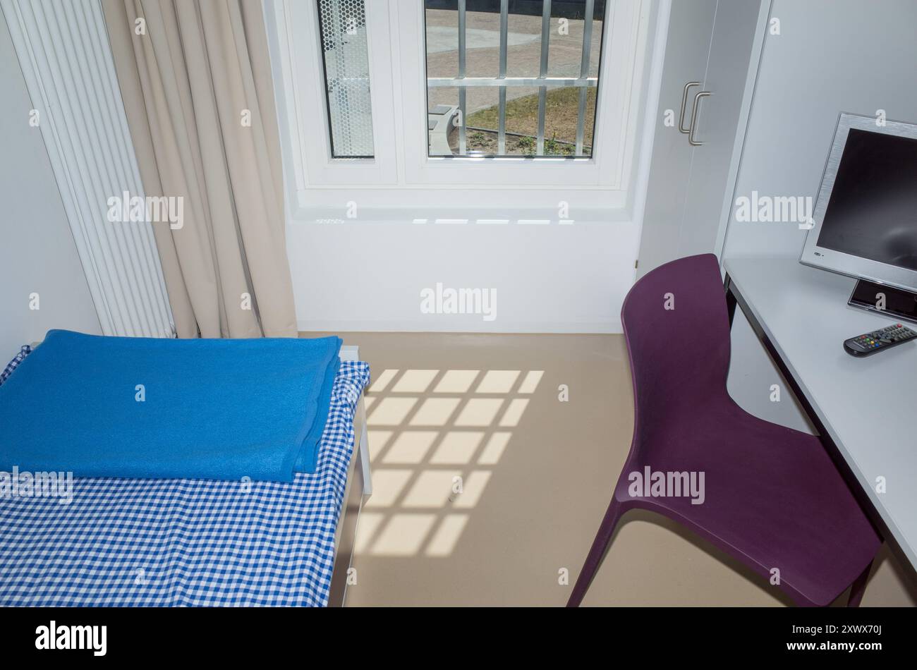 A contemporary prison cell in Heidering Prison, Brandenburg, Germany. This facility is designed for male adults with sentences of five years or less. The cell is bright and modern, emphasizing safety and security. Stock Photo