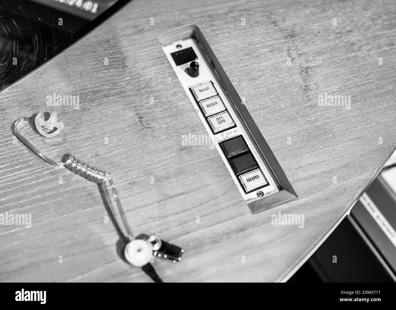 Detailed black and white image of a broadcast studio control panel at the NDR facility in Hamburg, Germany. The photo features various buttons for studio operations, showcasing the technical side of broadcasting. Stock Photo