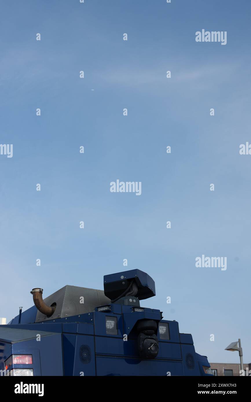 An imposing water cannon vehicle against a clear blue sky, conveying strength and authority. This image can serve as a metaphor for resilience, control, and the power to maintain order in challenging situations. Stock Photo