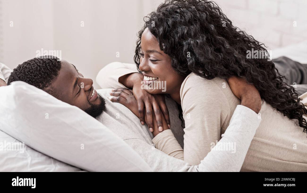 Romantic african couple spending time together in bed Stock Photo - Alamy