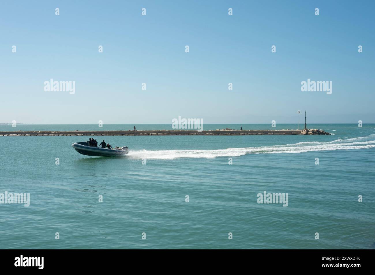 A small fast inflatable RIB enters the harbour at Margherita Di Savoia ...