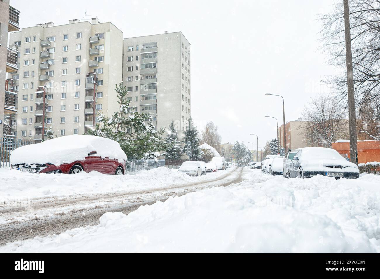A street in Krakow is covered with snow after a blizzard in winter. Car buried under the snow after heavy snowfall Stock Photo