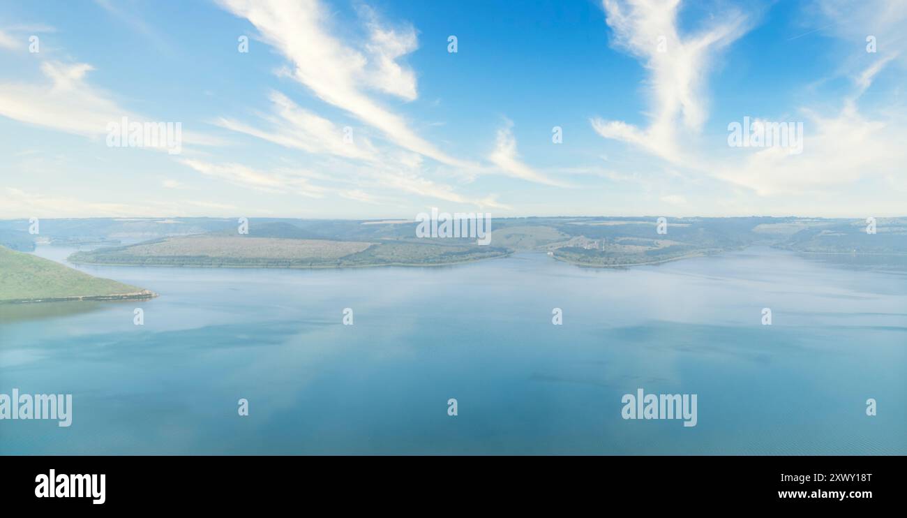 Serene lake view with clear blue skies and fluffy clouds. Beauty of ...