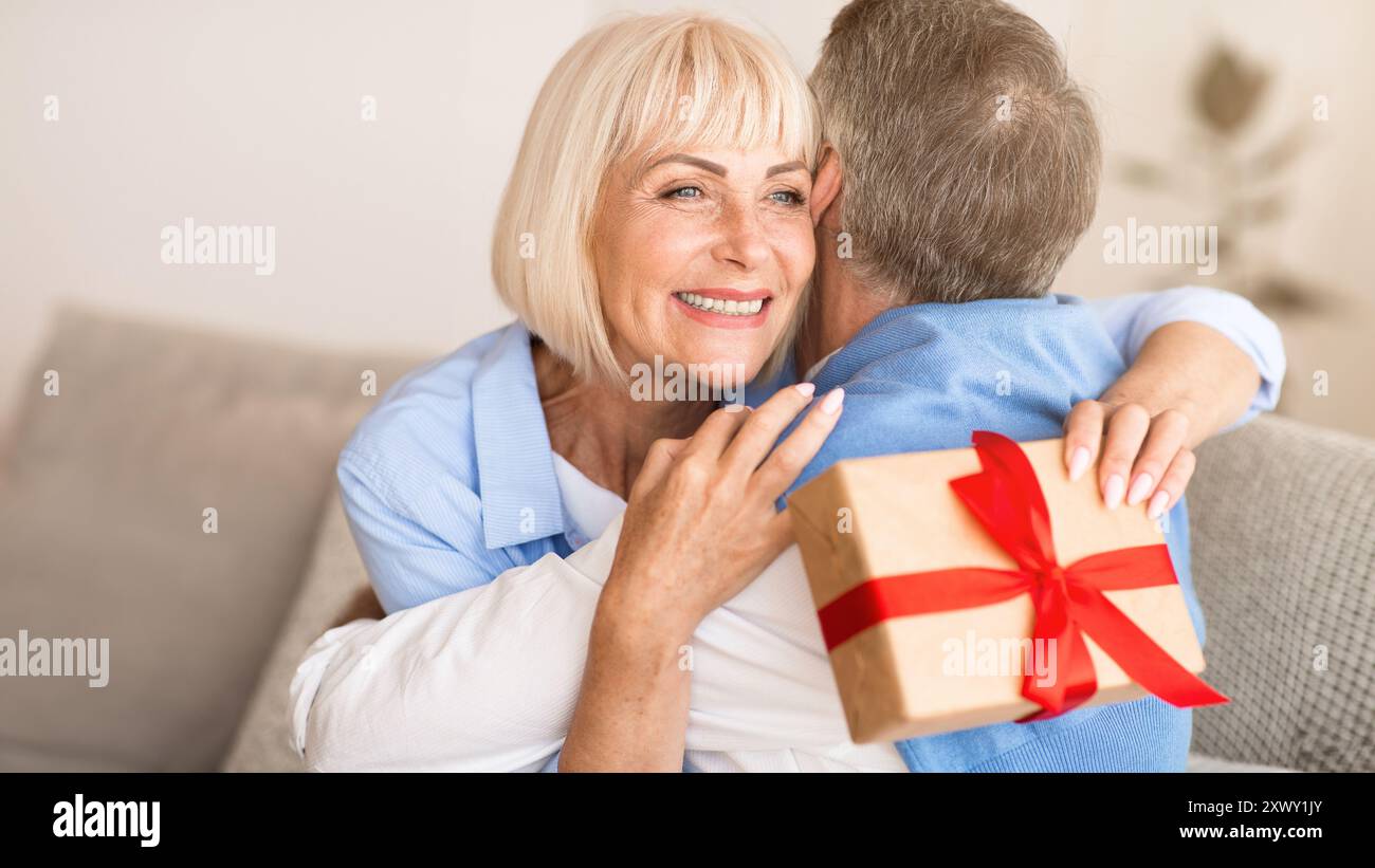 Happy wife hugging husband for the present Stock Photo - Alamy