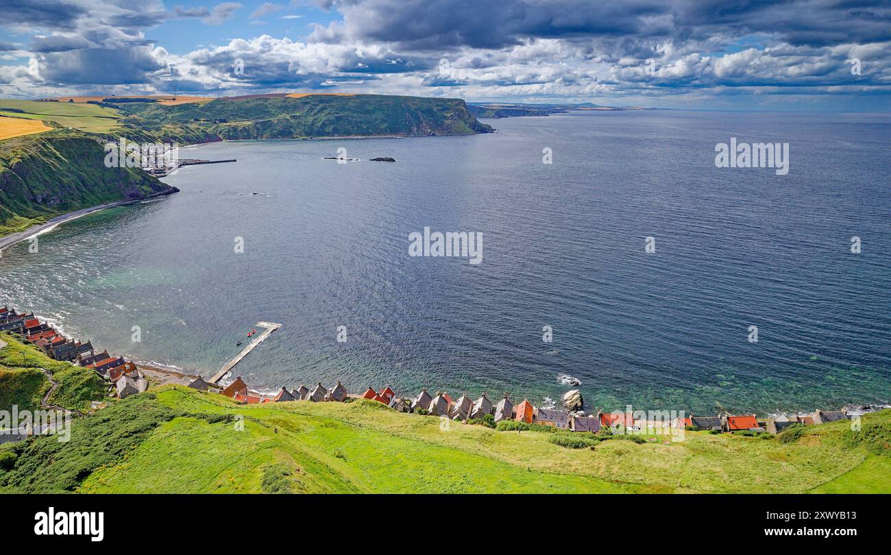 Crovie Aberdeenshire Scotland the Moray Firth and rain clouds in summer above the red roofs of the houses Stock Photo