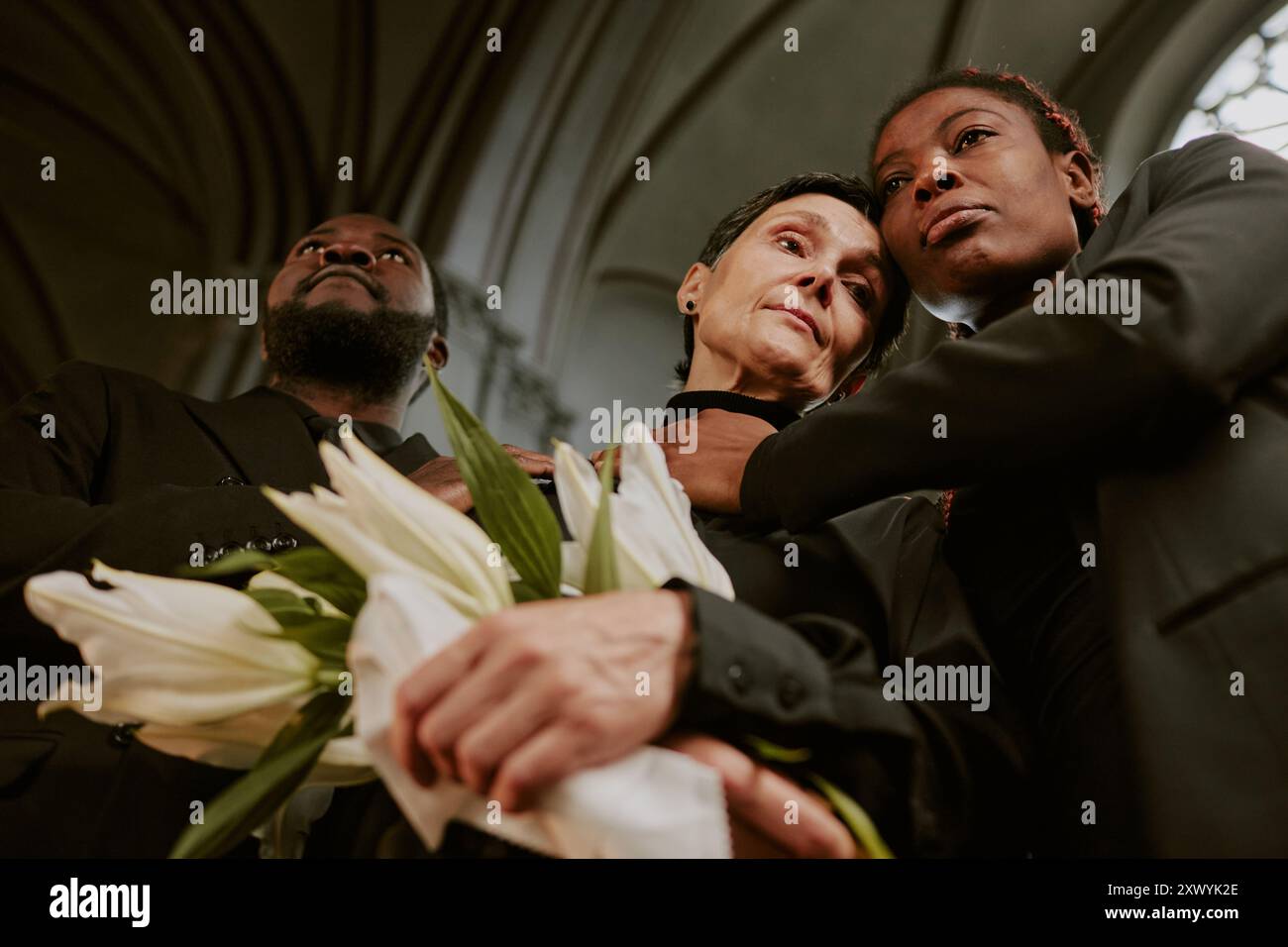 Mother holding photo son funeral The Economics of Grief and Disruption