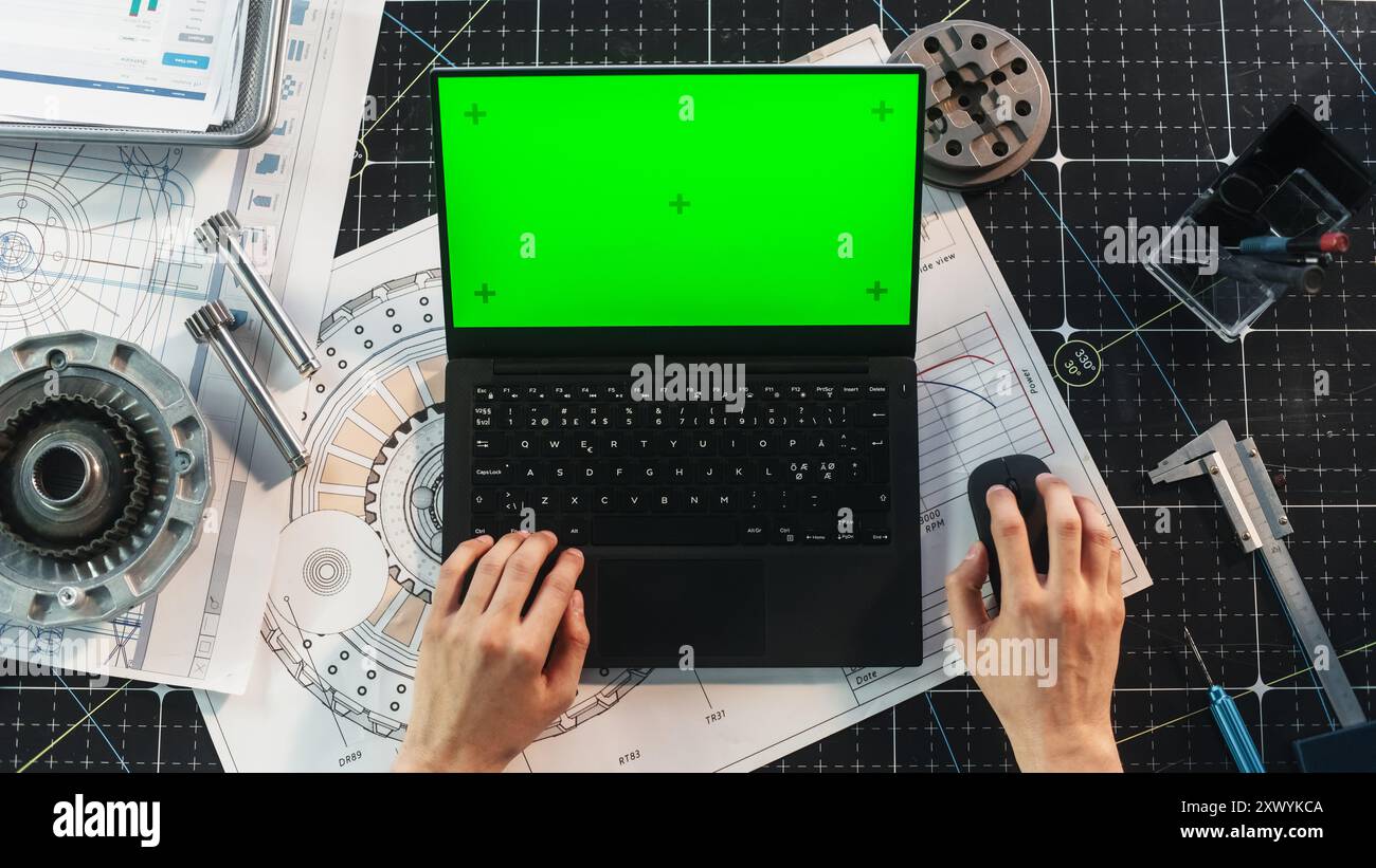 Anonymous Engineer Typing on Laptop Computer with Mock Up Green Screen Chromakey Display with Motion Tracker Placeholders. Scientist Corresponding with Work Partners by Email. Top Down View Stock Photo