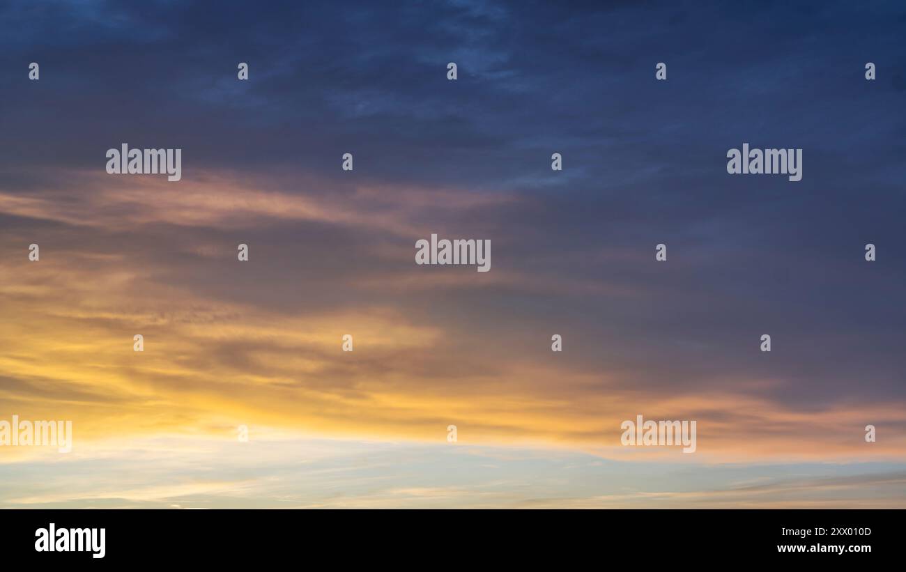 Glowing real sky at sunset texture background overlay. Dramatic red, orange, and purple clouds. High resolution photography perfect for sky replacemen Stock Photo