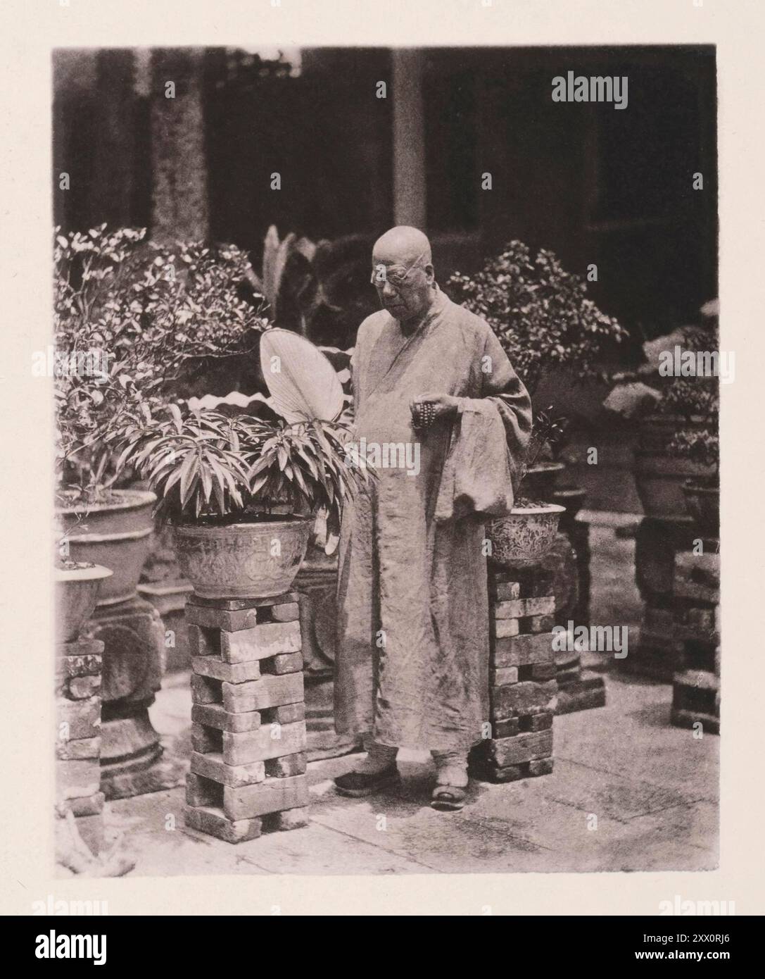 Vintage photo of Chief Priest of the temple of the Five Hundred Gods in Canton. Illustrations of Qing China, 1875 ... About three years ago, when I paid my first visit to this establishment, in company with a native gentleman from the Canton Customs Office, I was introduced to this Abbot.  He received us with great courtesy, conducted us to his private apartments, and there refreshed us with tea-cakes and fruit. The rooms he occupied were enclosed by a high wall, and approached through a granite-paved inner quadrangle, adorned with a variety of rare and beautiful flowers. Conspicuous among the Stock Photo