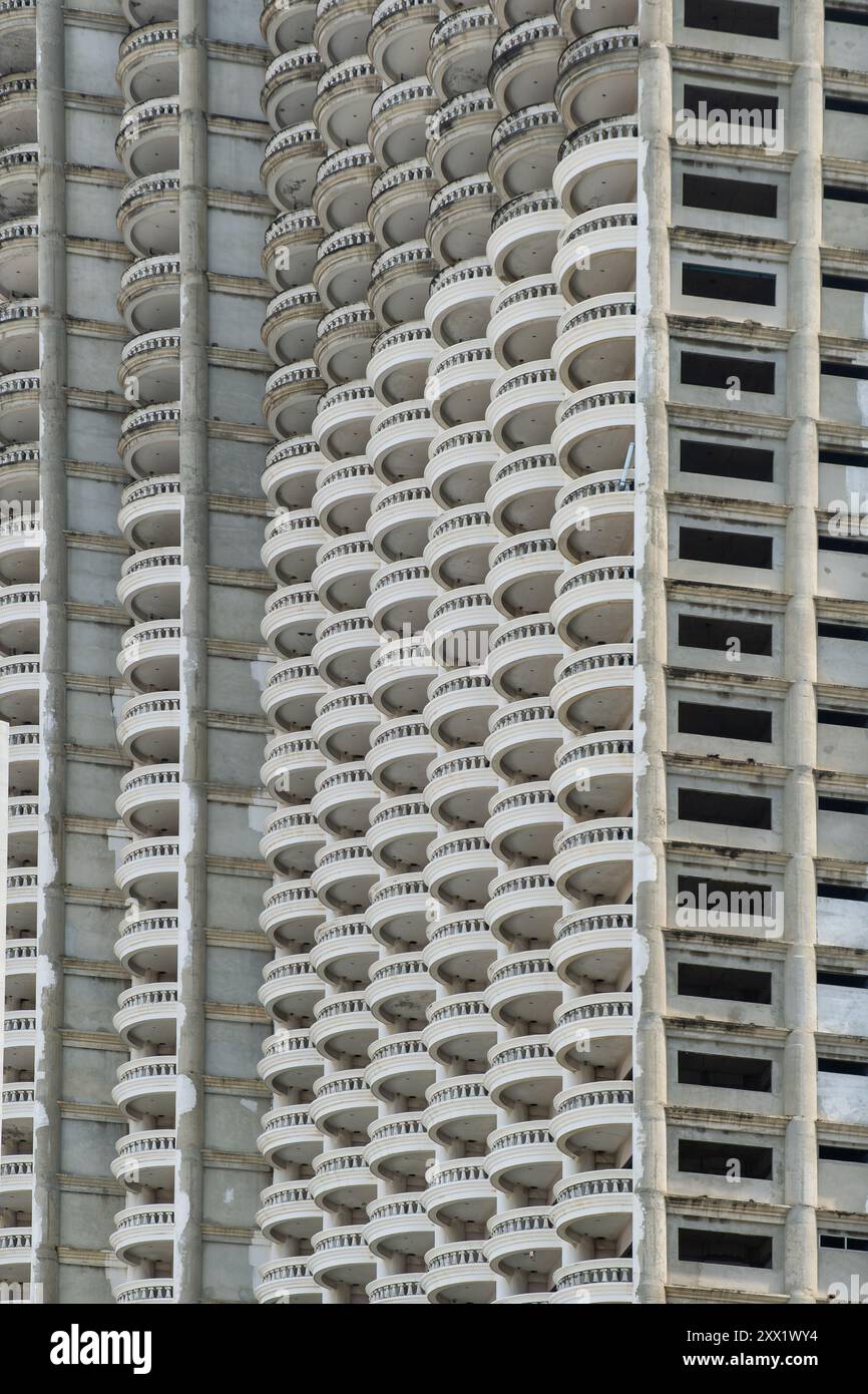 Unfinished high-rise building facade with repetitive pattern of curved ...
