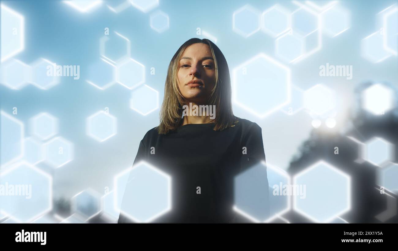 Young female soccer player standing confidently against a backdrop of glowing hexagonal patterns and light trails. Ideal for illustrating themes of sp Stock Photo