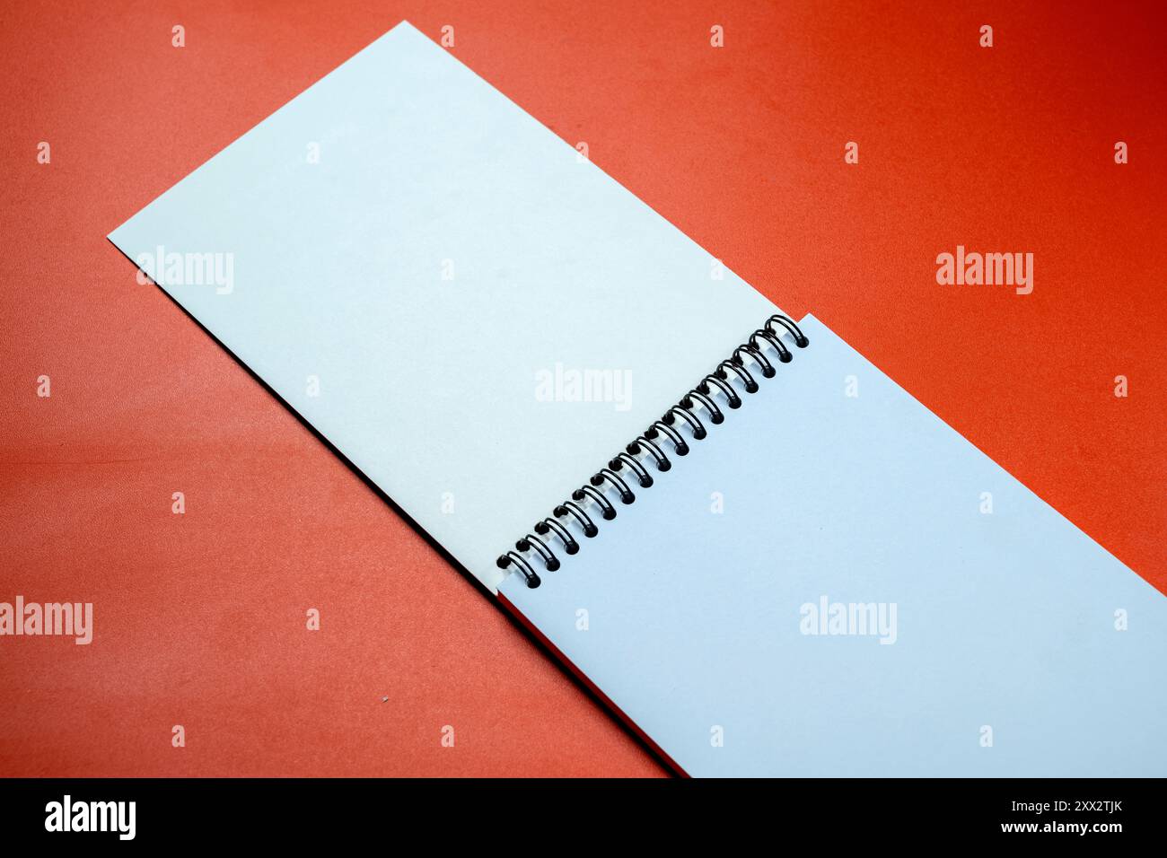 A spiral notebook with a red background. The notebook is open to a ...