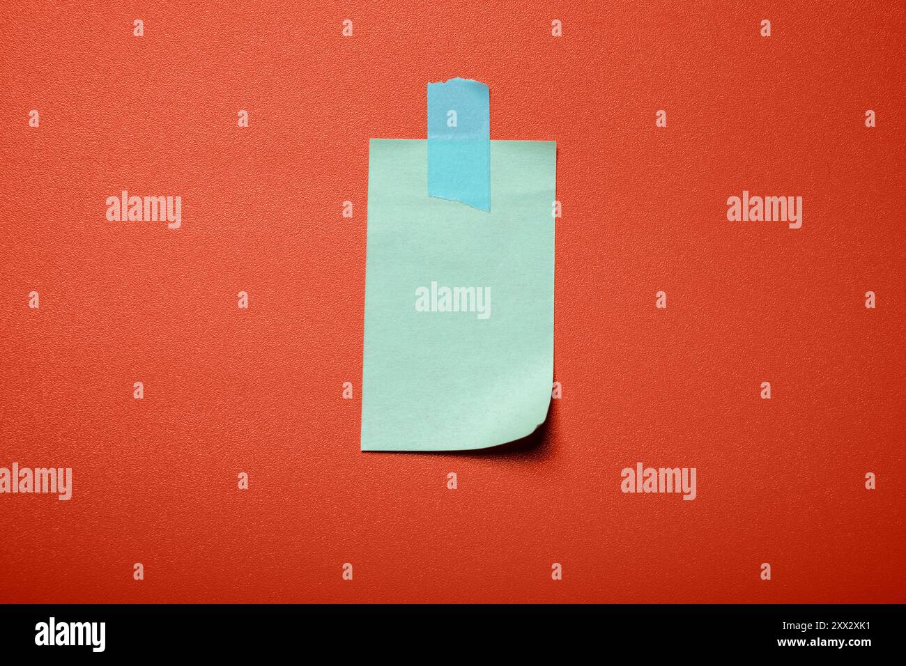 Stuck Up Notes A blue sticky note is stuck to a red wall. The note is small and has a ...