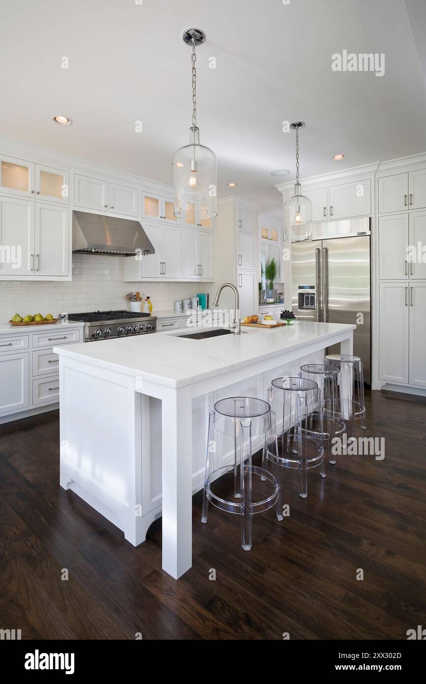 White kitchen with dark wood floors and stainless appliances Stock ...