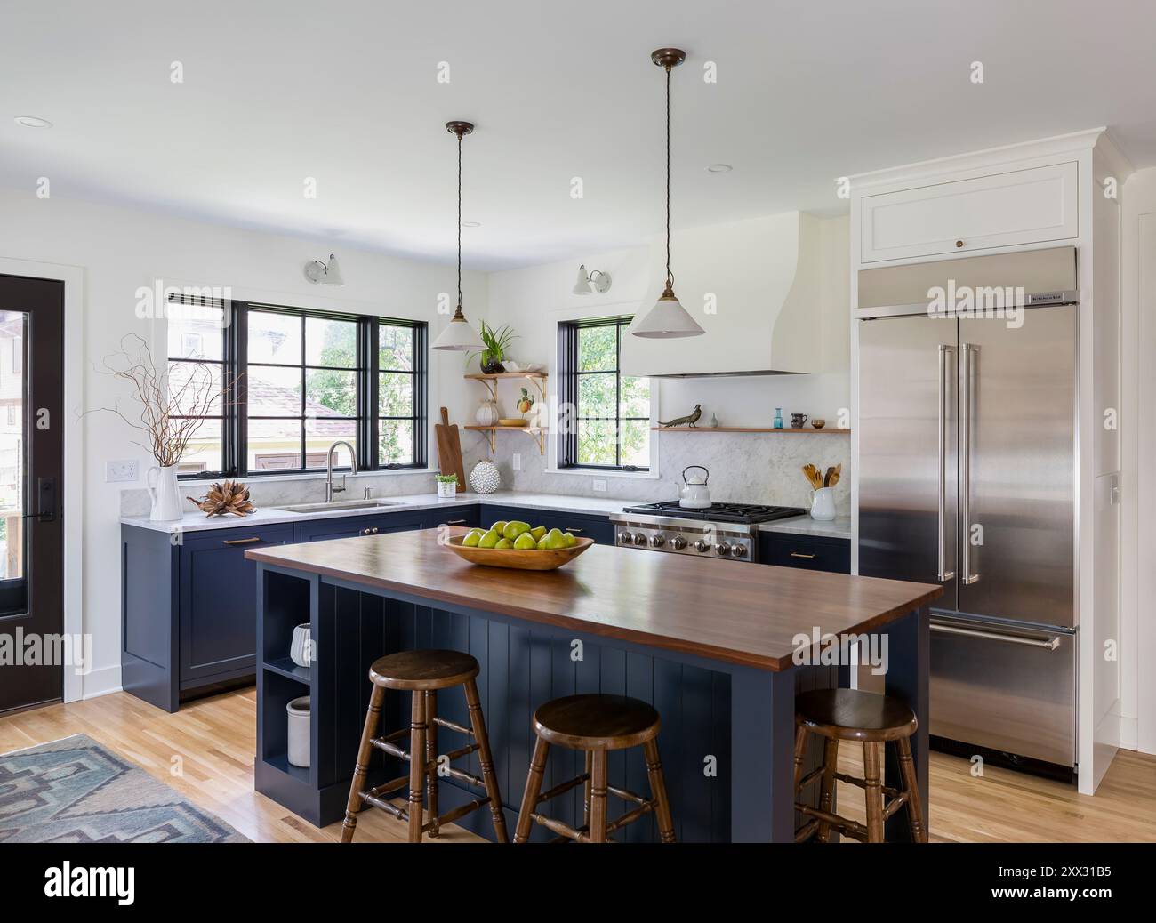 Kitchen with blue cabinets and white marble countertops and walnut island countertop Stock Photo