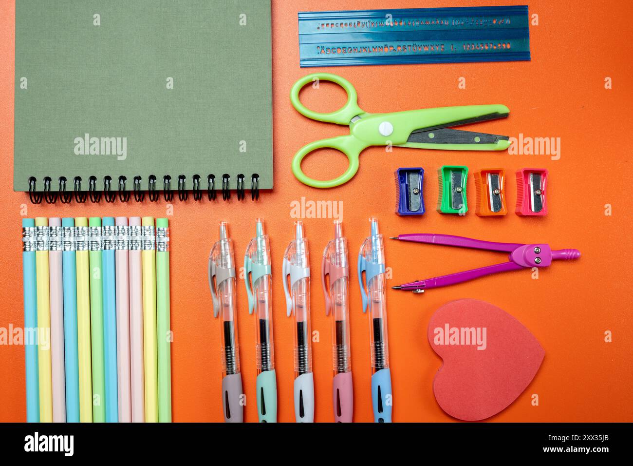 A collection of school supplies including pencils, pens, scissors, and ...