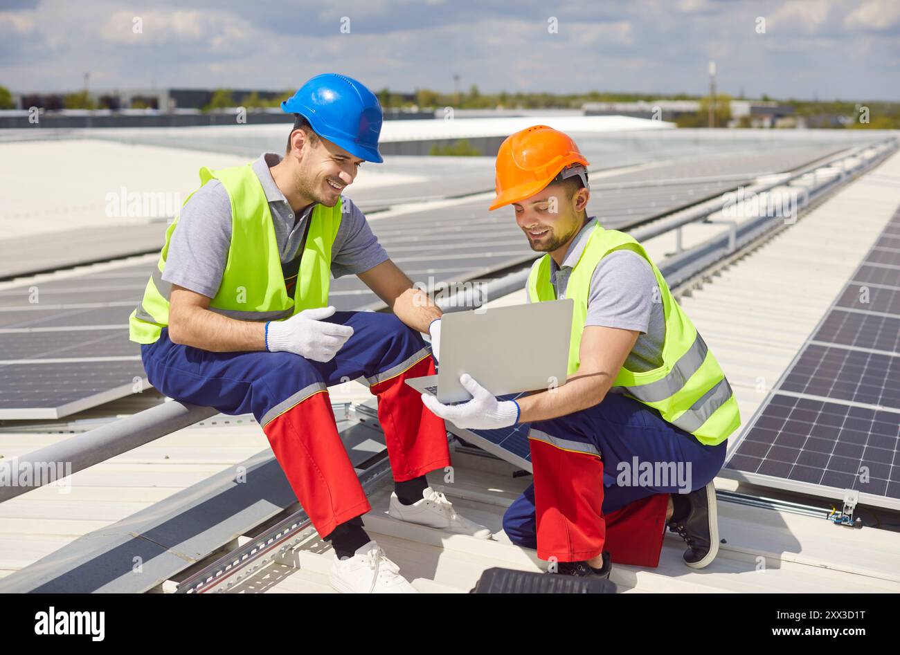 Solar Panel Technicians Conducting Installation Or Maintenance Using Laptop Stock Photo