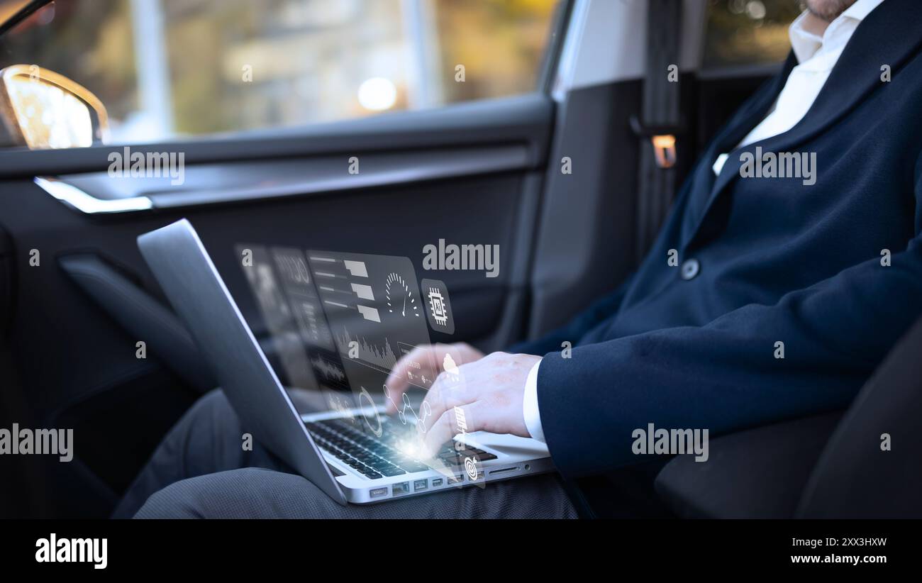 A businessman dressed in a formal suit is working on a laptop inside a ...