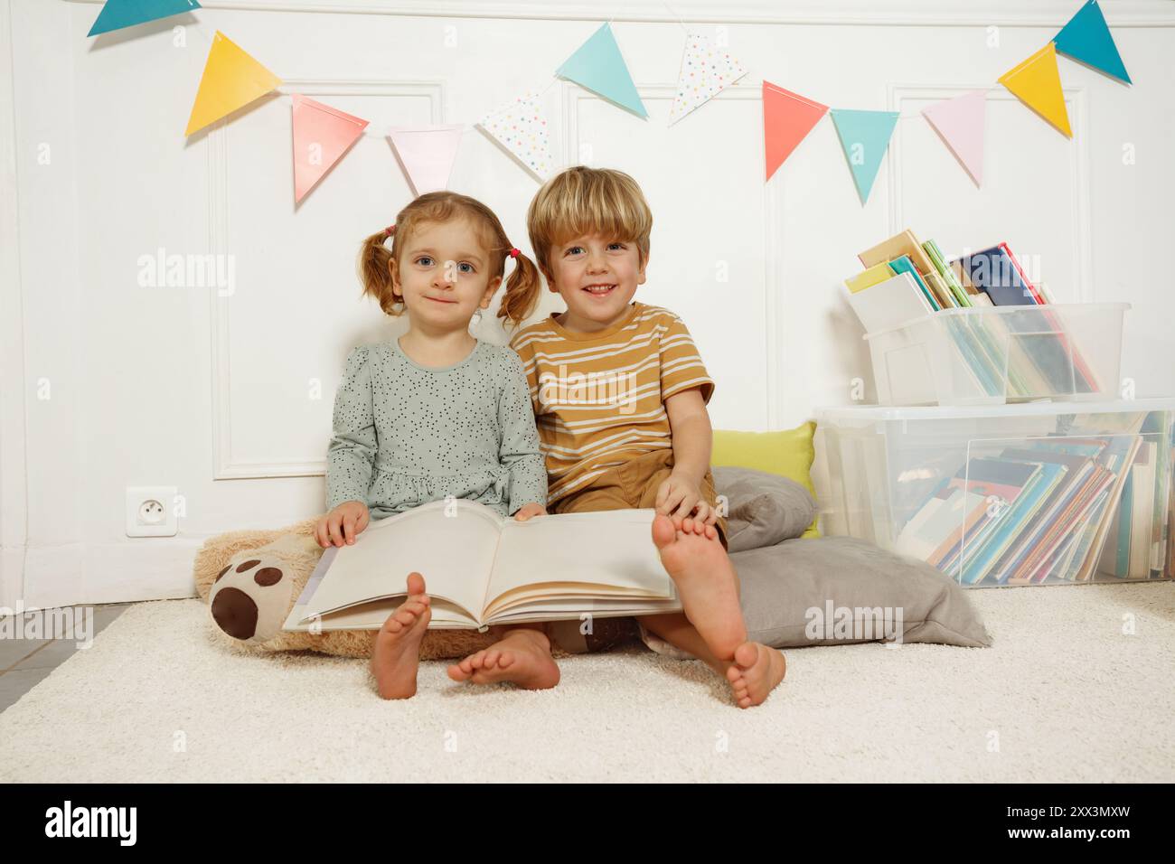 Little boy and girl smiling reading books in nursery library Stock ...